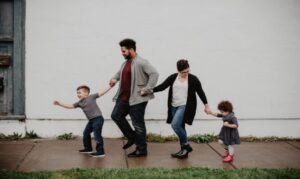 family holding hands walking on sidewalk after rain