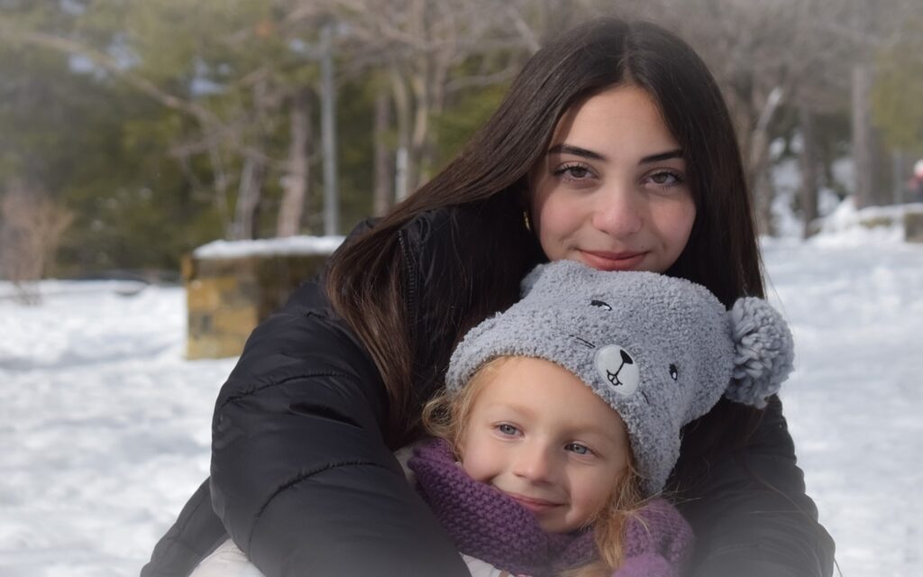 Young mother with daughter in the snow